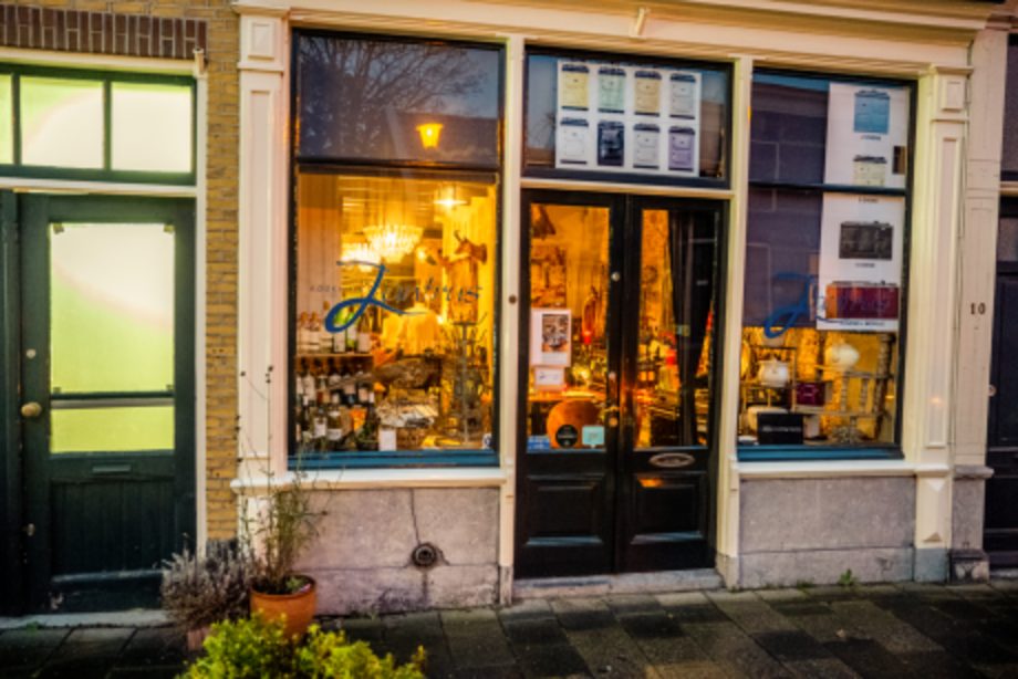 De verlichte gevel van Jantrus aan de Naaierstraat bij avond