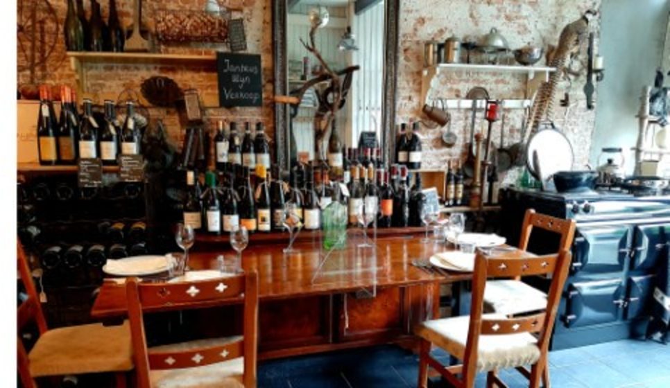 De gedekte tafel met wijnflessen en de AGA op de achtergrond